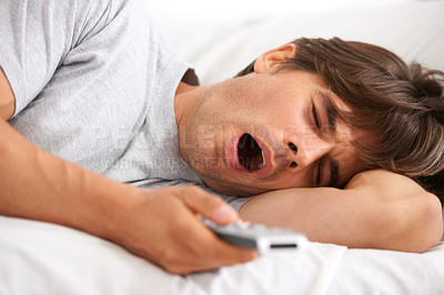 Buy stock photo Tv, yawn and tired man in bed with remote control for streaming movies in his home. Fatigue, relax and morning lazy male in a bedroom with television, show or film while on vacation in his house