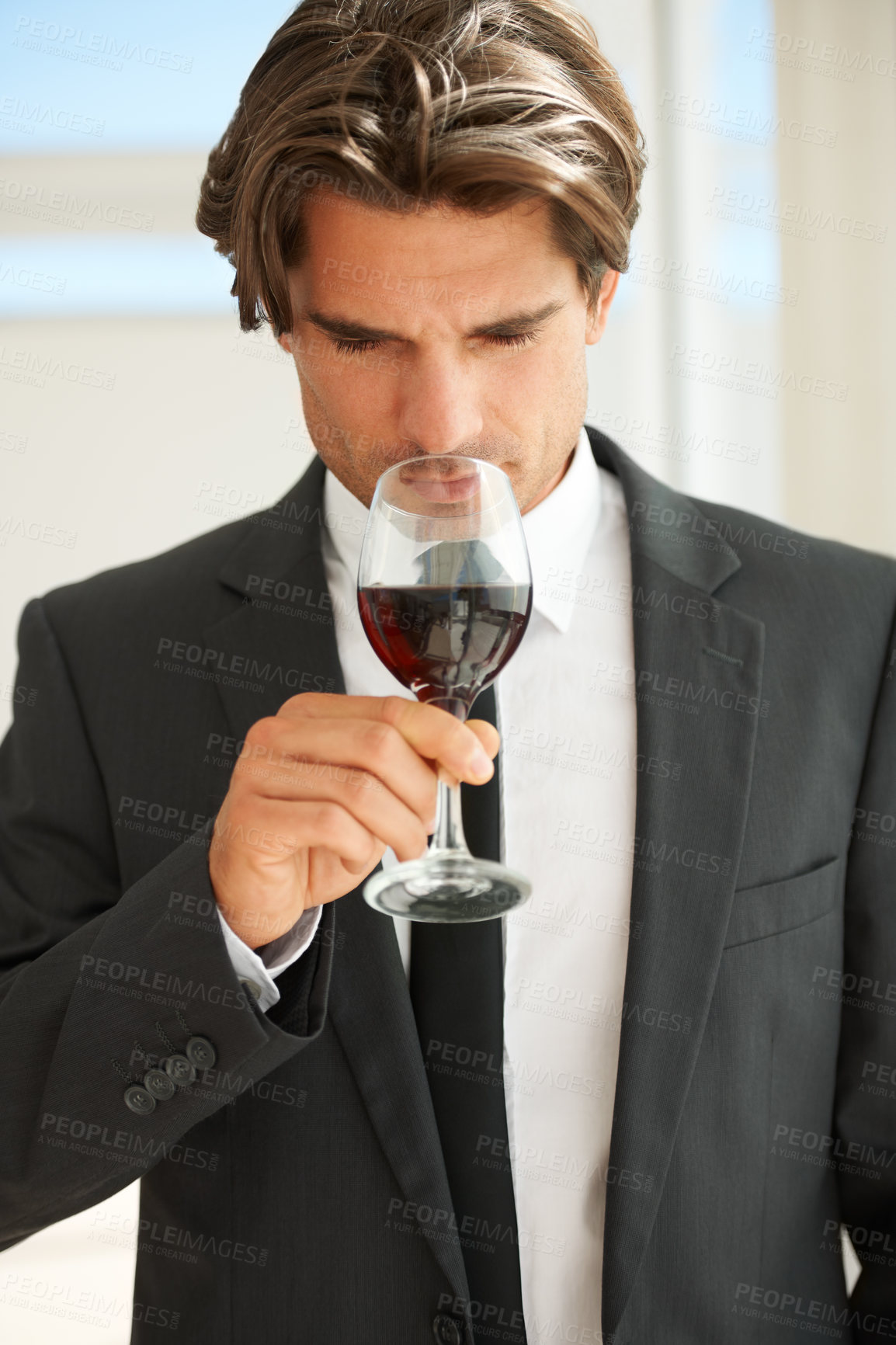 Buy stock photo A handsome wine connoisseur enjoying a glass of red wine