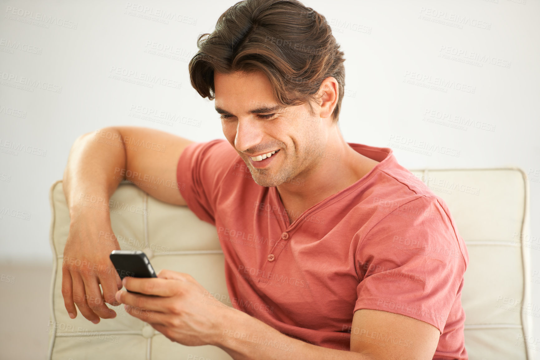 Buy stock photo A handsome young man reading a text message on his phone