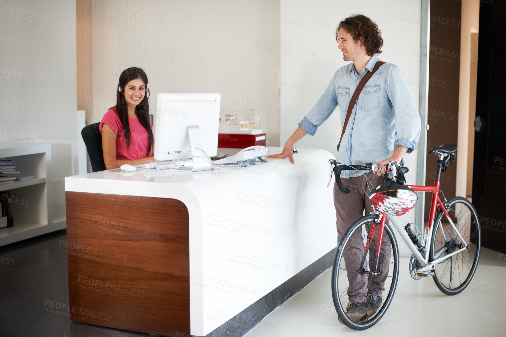 Buy stock photo Office, desk and man with bike for business, travel and talking about commute to work with receptionist in morning. Businessman, bicycle and conversation with woman in administration or secretary