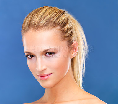 Buy stock photo Portrait, beauty and ponytail of a woman closeup in studio on a blue background for skin wellness or cosmetics. Face, skincare and cosmetics with a natural young model at the salon for dermatology