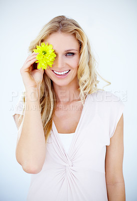 Buy stock photo Beauty, happy and portrait of a woman with a flower in a studio with a cosmetic, natural and face routine. Makeup, smile and female model with a yellow floral plant isolated by a white background.