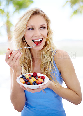 Buy stock photo Pretty young woman enjoying her fruit salad