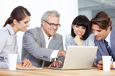 Buy stock photo A team of businesspeople working on a laptop together