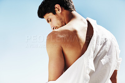 Buy stock photo A mysterious attractive male taking off his white shirt in the summer sun - Copyspace