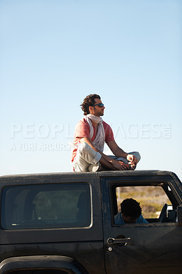 Buy stock photo Road trip, man and sitting on car roof for scenery, nature and fresh air on adventure or vacation in South Africa. People, tourist or traveler on rooftop of van with sunglasses for view or journey