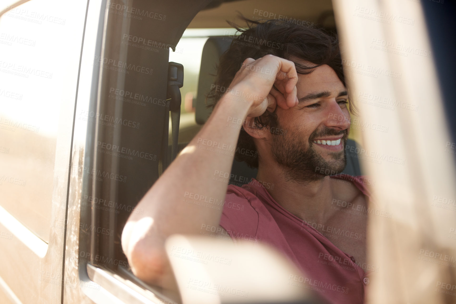 Buy stock photo A young man smiling and laughing while on a road trip