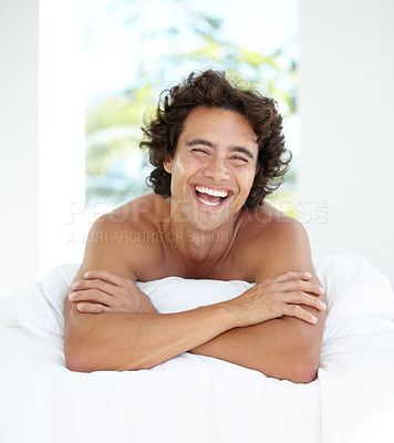 Buy stock photo Laughing, portrait and a handsome man in bed for sleep, relaxing and rested in the morning. Wake up, resting and a guy in bedroom looking cheerful after sleeping or nap in the comfort of a house