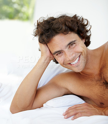 Buy stock photo Portrait, happy and bed with a man lying in the bedroom of his home to relax or rest on a summer morning. Smile, wellness or lifestyle with an attractive young male person relaxing alone in his house