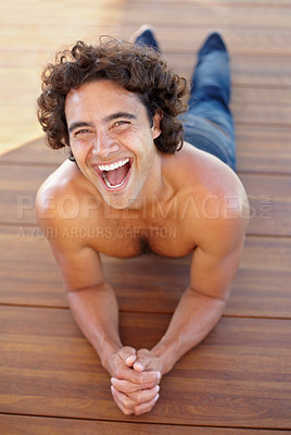 Buy stock photo Portrait of a sexy young man lynig down on a wooden floor