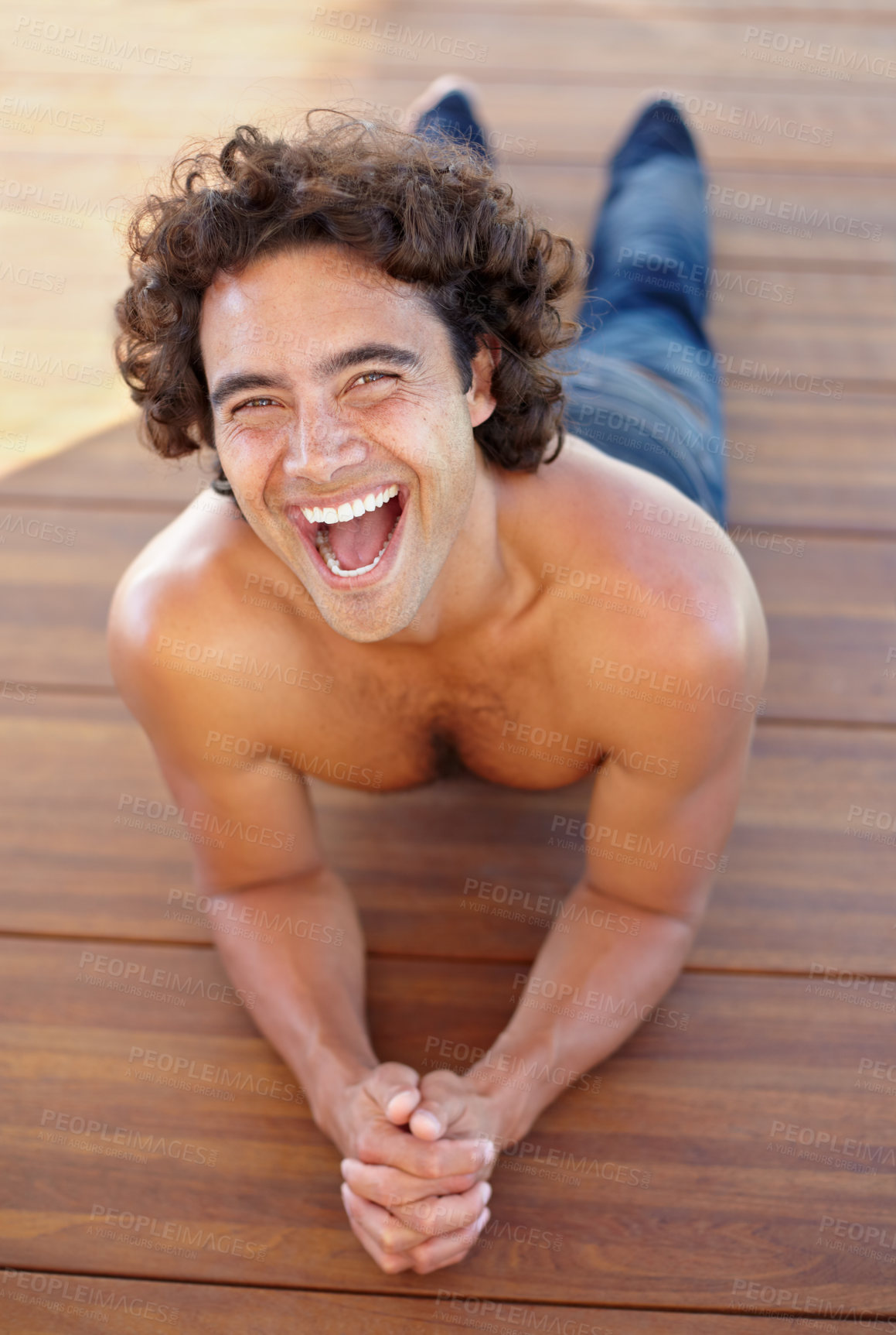 Buy stock photo Portrait of a sexy young man lynig down on a wooden floor
