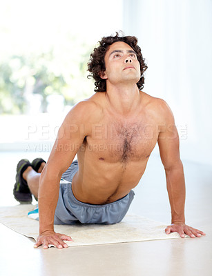Buy stock photo Yoga, man and cobra stretch in home for health, wellness and flexibility in house. Pilates, stretching and male person, yogi or athlete training, holistic workout and exercising for fitness on mat.