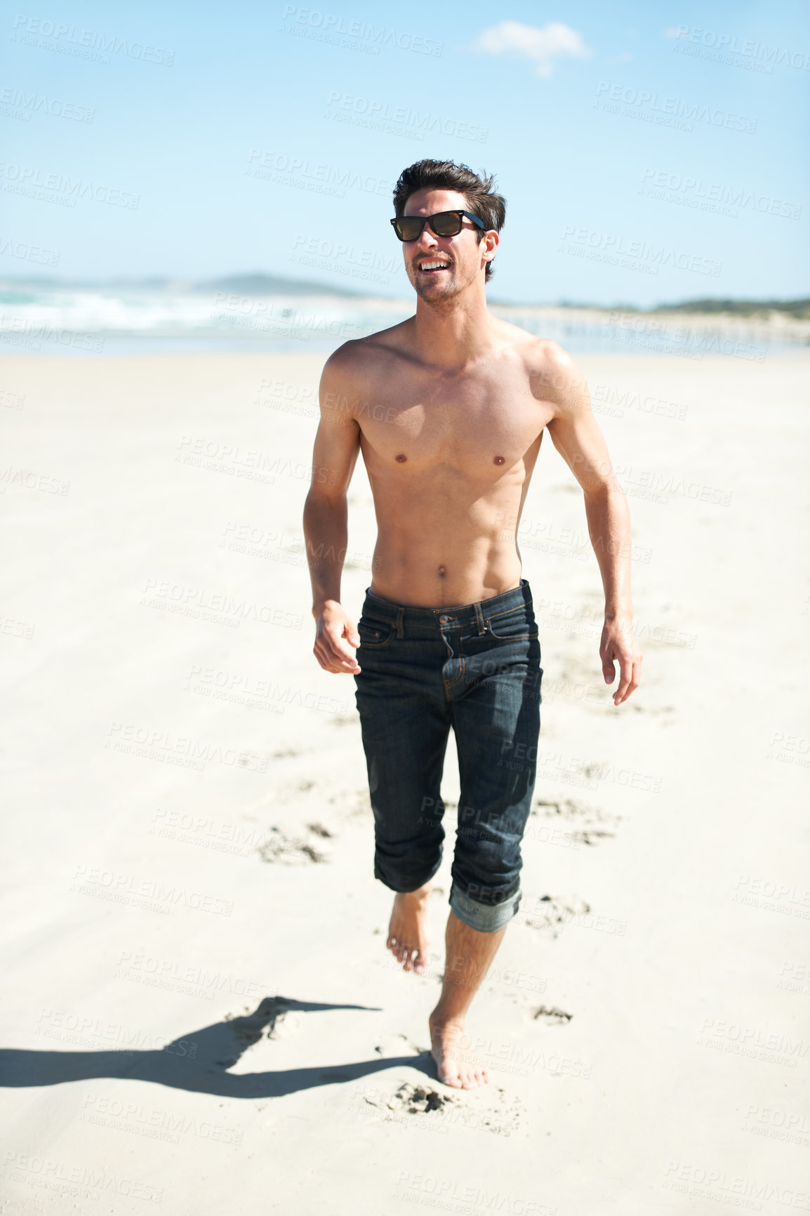 Buy stock photo An attractive young man walking on the beach