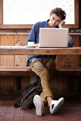 Buy stock photo A young man on his laptop, trying to stay focused