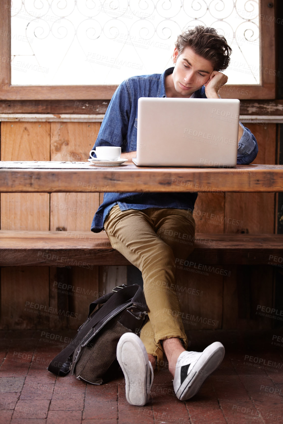 Buy stock photo A young man on his laptop, trying to stay focused