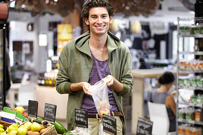 Buy stock photo A young man at the store buying fruit