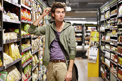 Buy stock photo Confused, portrait and a man doing grocery shopping at a supermarket with doubt and thinking. Inflation, idea and a male shopper at a store with surprise at groceries, sale offer or customer deal