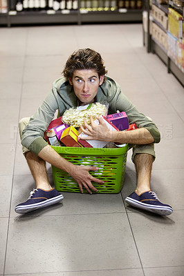 Buy stock photo Man, grocery shopping and market, stress about inflation and expensive food, overwhelmed in supermarket. Groceries in basket, retail and customer shocked by price, choice and purchase with fear