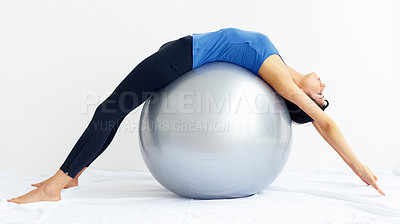 Buy stock photo Young woman stretched over a swiss ball while isolated on white