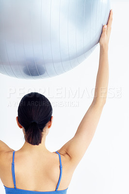 Buy stock photo Rear view of a young woman holding up a swiss ball