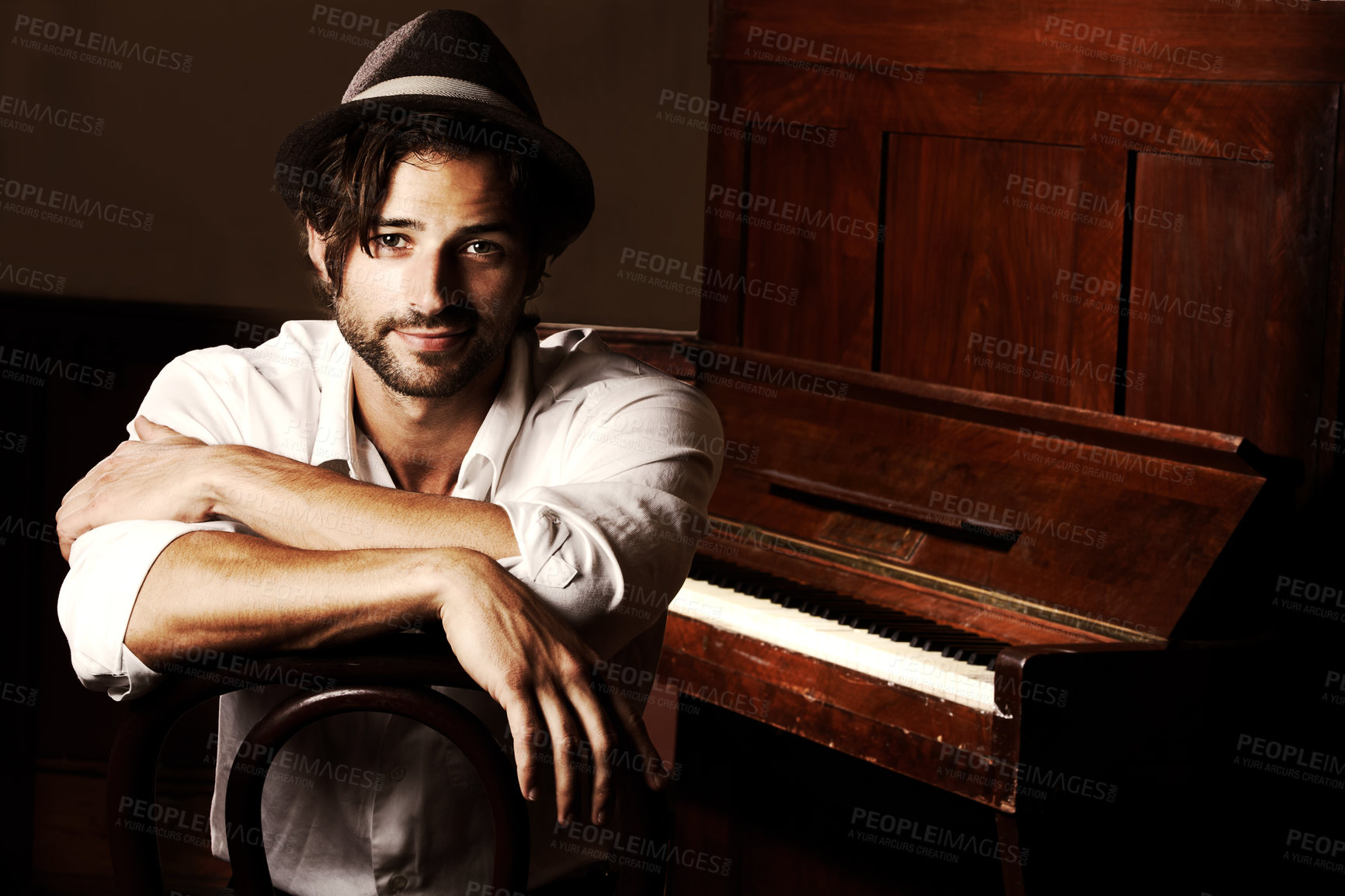 Buy stock photo Portrait of a young musician sitting in front of his piano