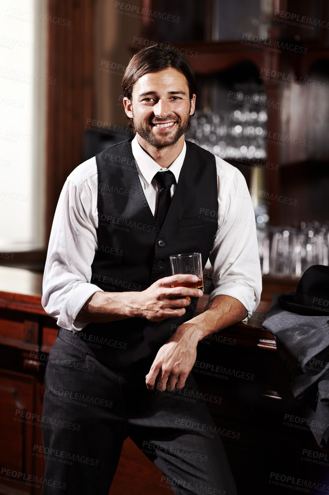 Buy stock photo Portrait of a well-dressed young man standing at a bar with a drink