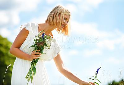 Buy stock photo Happy, woman and picking flowers in a garden with freedom, fun and peace in the countryside. Smile, adventure and female person with nature, bouquet or fresh floral bunch on a field while traveling