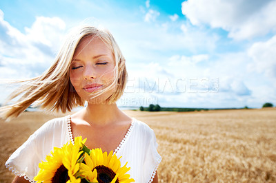 Buy stock photo Freedom, nature and calm woman with a sunflower on a wheat field for travel or vacation. Peace, face and female person in nature with a flower in countryside for holiday, journey or adventure outdoor