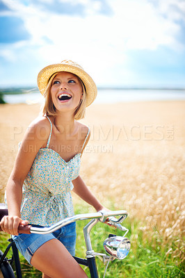 Buy stock photo Woman laughing on bicycle in the countryside, happiness and travel on journey or thinking outdoor. Funny, bike and excited person smile at field on transport, freedom and cycling in nature in summer