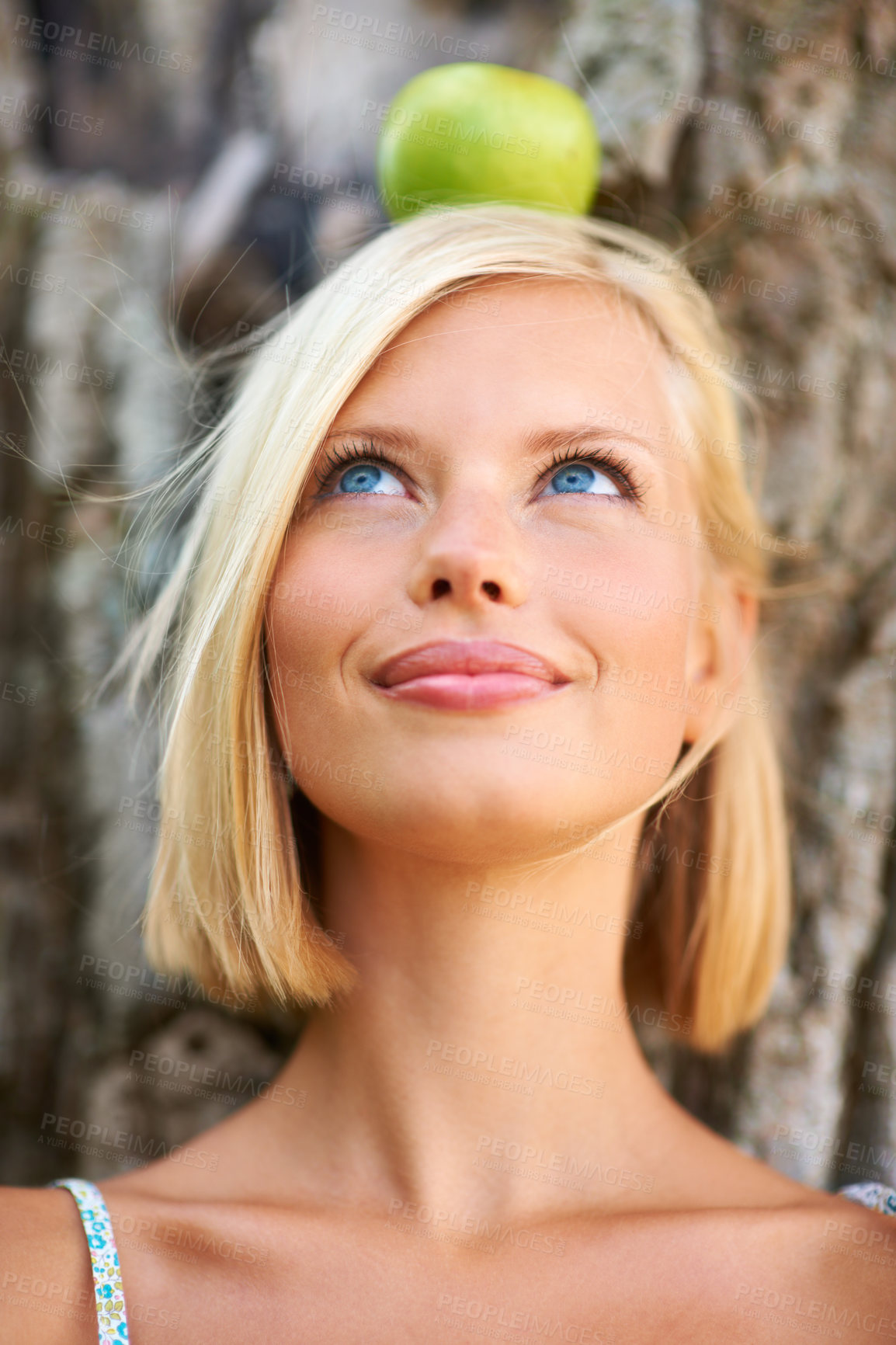 Buy stock photo Woman, face and thinking with apple balance by tree for natural nutrition, diet or health and wellness in nature. Female person or blonde with organic fruit in wonder for healthy, vitamin and snack