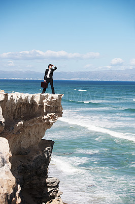 Buy stock photo Thinking, cliff and business man on edge by ocean for opportunity, problem solving and solution. Professional, bankruptcy and confused corporate worker on rocks for danger, risk and fail in company