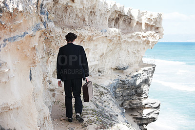 Buy stock photo Businessman, thinking and walking with briefcase by ocean on ledge for mental health in back view. Person, anxiety or depression with mindset for difficulty in decision making in development space