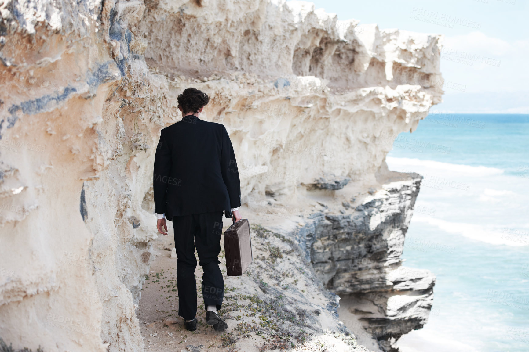 Buy stock photo Businessman, thinking and walking with briefcase by ocean on ledge for mental health in back view. Person, anxiety or depression with mindset for difficulty in decision making in development space