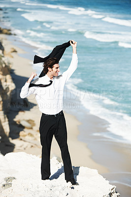 Buy stock photo Cliff, success or happy business man in celebration of victory or freedom on holiday at beach in suit. Ocean, goal or excited employee winner on mountain in nature with achievement or job promotion