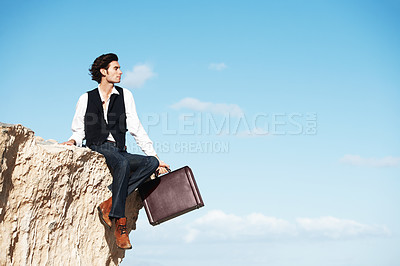 Buy stock photo Handsome businessman sitting with his legs dangling over the side of a cliff next to copyspace