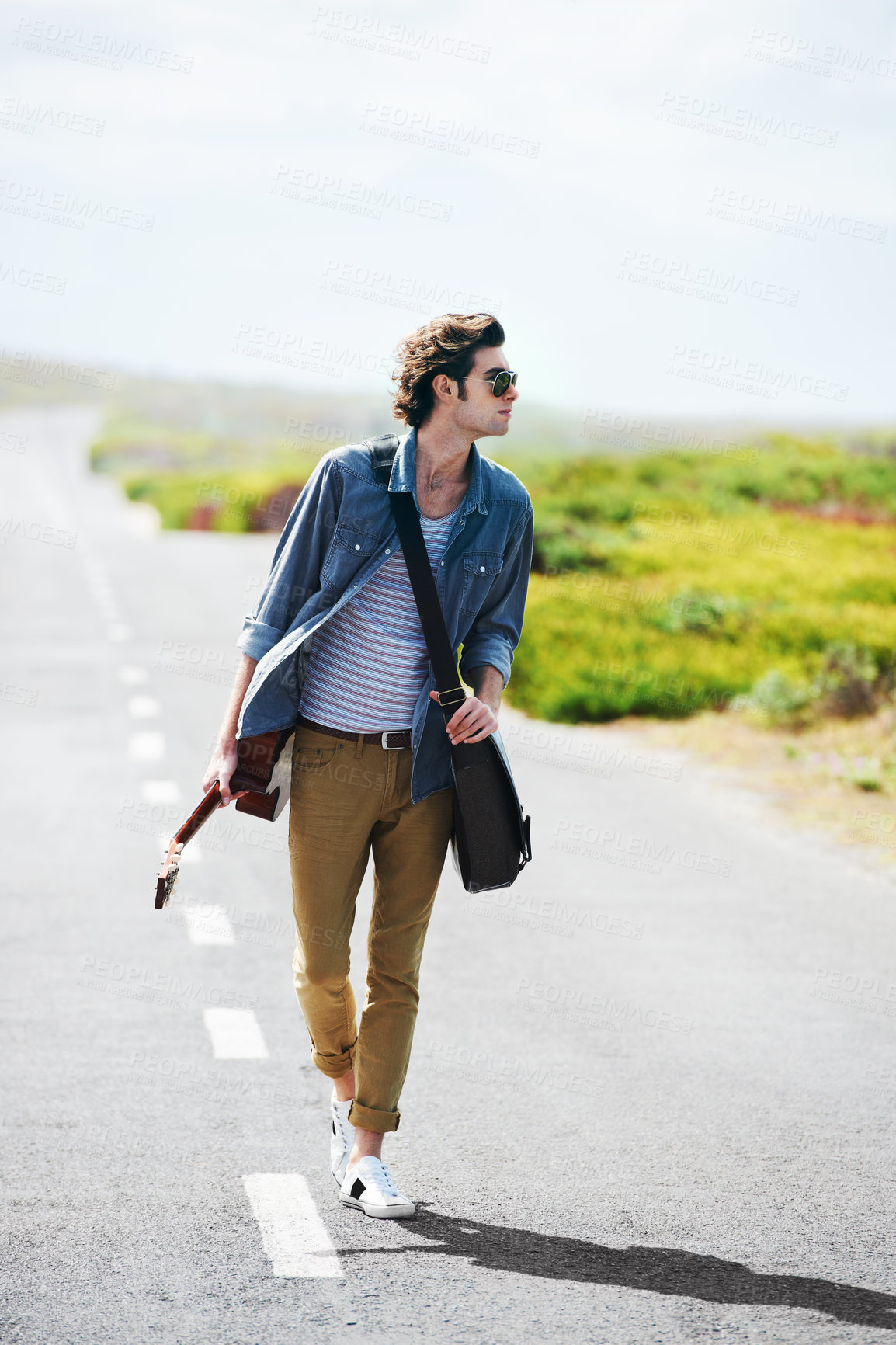 Buy stock photo Musician, walking and man with a guitar on a road trip, highway or journey in countryside. Guitarist, trekking or lost on adventure and explore path in landscape with freedom on holiday or vacation