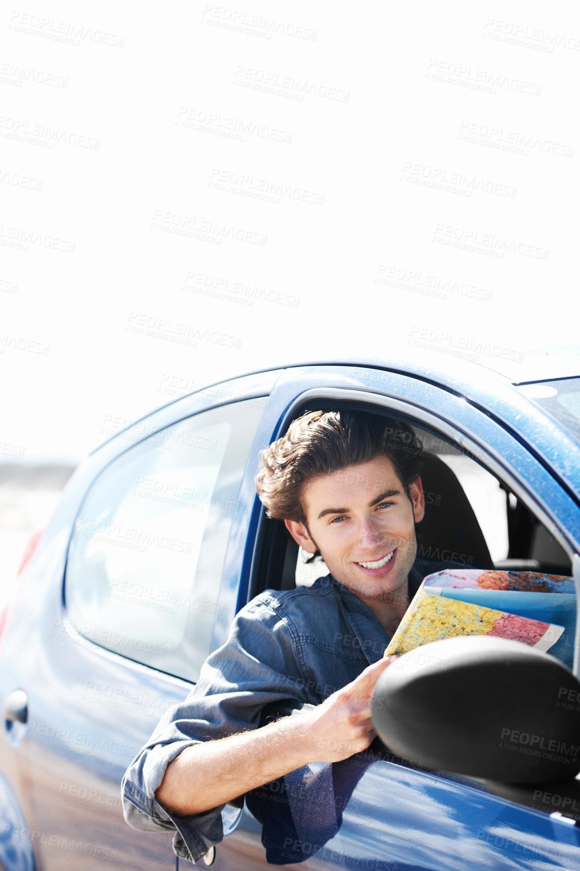 Buy stock photo Young man sitting in his car ands smiling at the camera while holding a map
