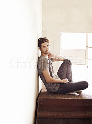 Buy stock photo Portrait, depression and alone with a man on a staircase in his home, sitting on the landing by a window. Lonely, mental health and relax with a handsome young male on steps or stairs in his house