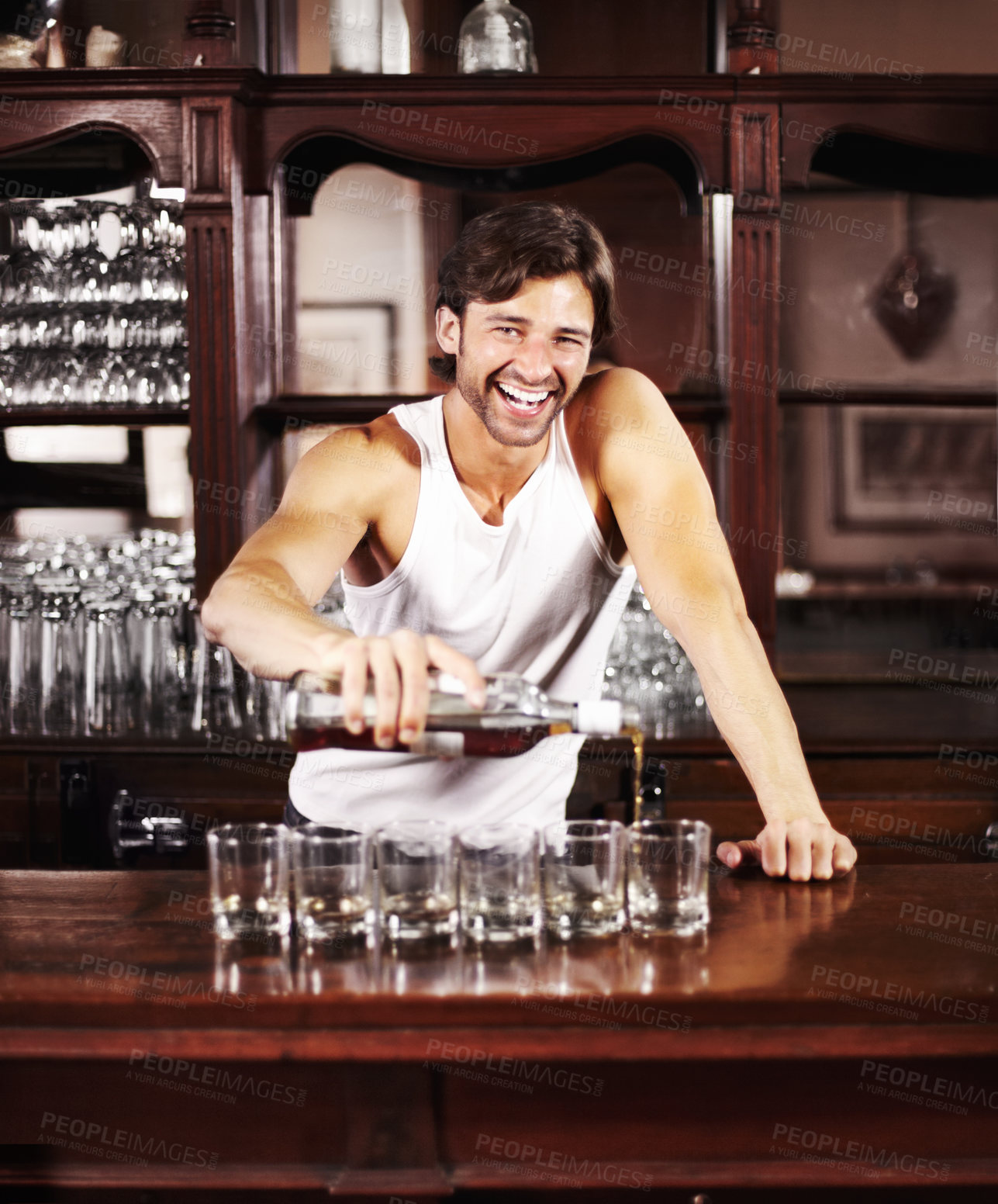 Buy stock photo Portrait, whisky and alcohol with a handsome barman behind the counter of a pub to serve drinks during happy hour. Smile, glass and drink with a man bartender pouring a whiskey beverage in a bar