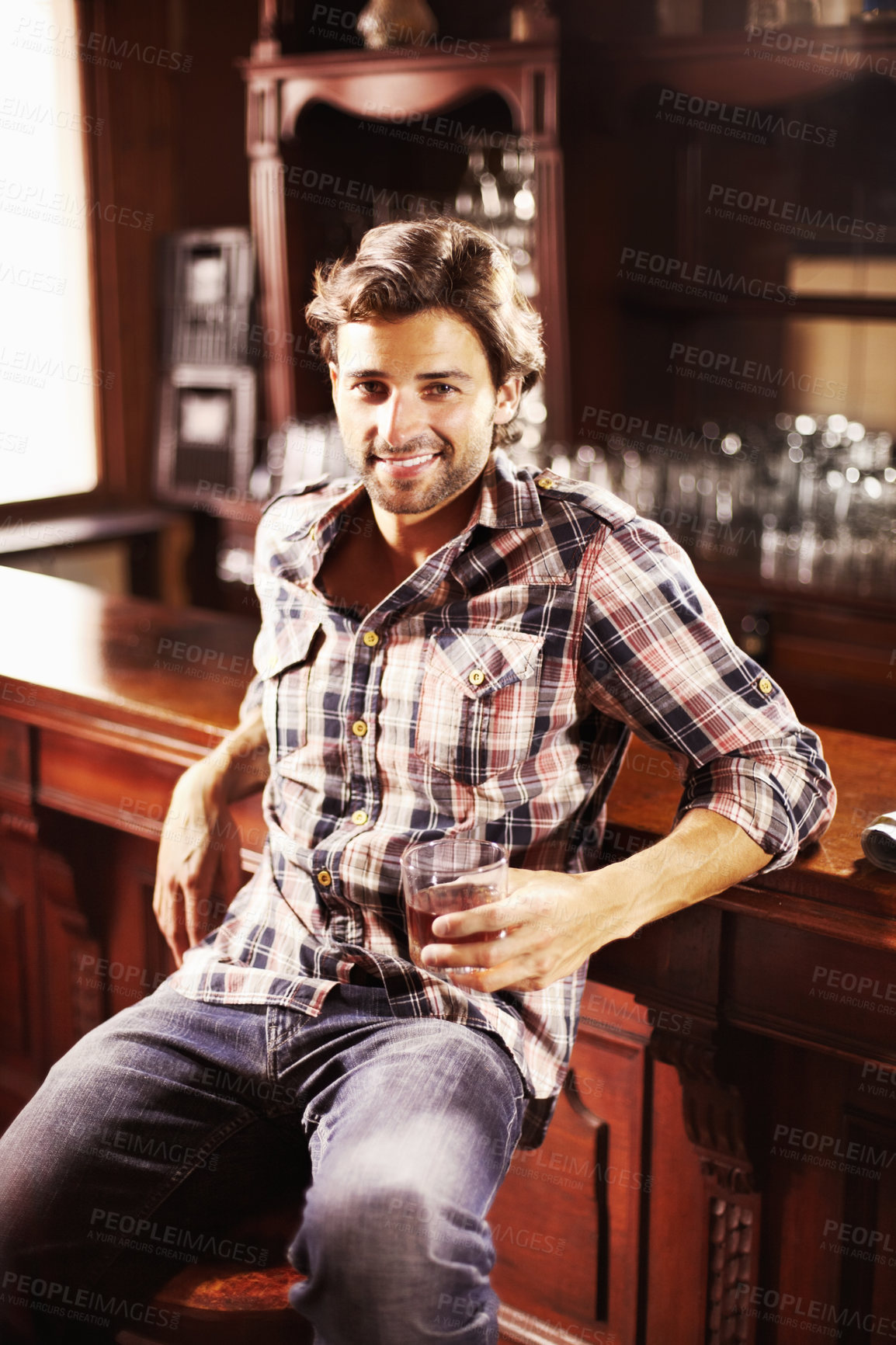 Buy stock photo Portrait, smile and man with whiskey in pub sitting by counter alone. Alcohol, happiness and male person in bar for drinking liquor, beverage or drink in tavern, relaxing and enjoying time alone.