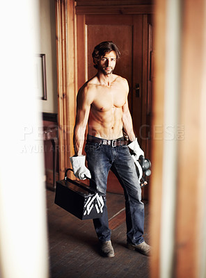 Buy stock photo Attractive young handyman standing shirtless while holding his tools