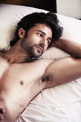 Buy stock photo Handsome young man lying awake and thinking while in bed