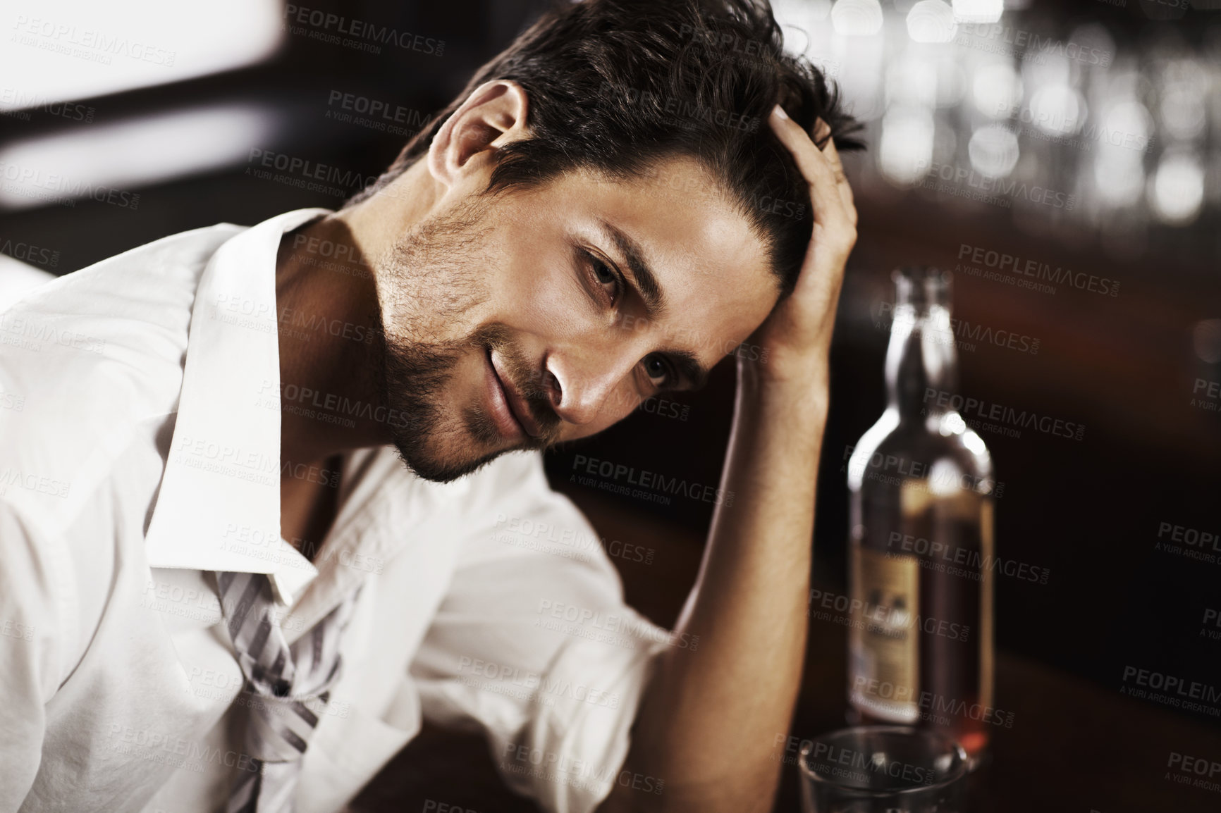 Buy stock photo Bar counter relax man and portrait of happy hour with alcohol and whiskey after work. Bottle, young male person and hand in hair in a restaurant with a playboy guy with a glass and confidence in pub