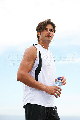 Buy stock photo Thinking, running and a man with water and music after a workout, exercise or outdoor cardio. Break, relax and a runner with a drink while listening to a podcast after training or sports in nature