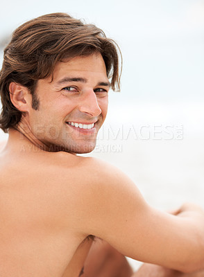Buy stock photo Shot of a handsome young man enjoying a relaxing day at the beach