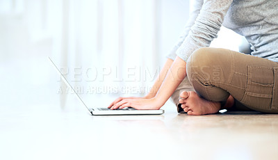 Buy stock photo Cropped image of a young woman sitting on the floor and browsing her laptop