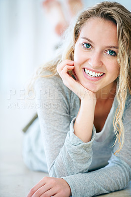 Buy stock photo Closeup of a cute young blonde lying on the floor and smiling at you - Copyspace