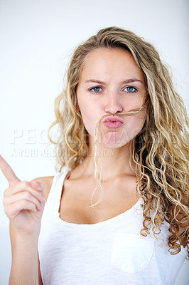 Buy stock photo Woman, portrait and hair mustache for playful mood, finger or funny personality. Female person, face and hand gesture on white studio background for confident attitude, pointing or comedy joke