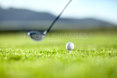 Buy stock photo A golf club ready to tee-off with a white ball on a golf course