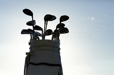 Buy stock photo Closeup of a golf bag and a variety of clubs isolated against the sky outside. Zoomed in on collection of sports equipment during the day against blue background and copyspace. Ready to practice golf